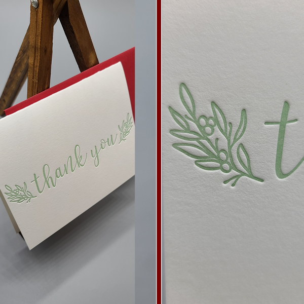 Letterpress printed thank you folding card. Celedon green ink. The image shows the card with a red envelope behind it, sitting on a small wooden easel. There is a second image -split screen- of an up close look at berries and leaves detail.
